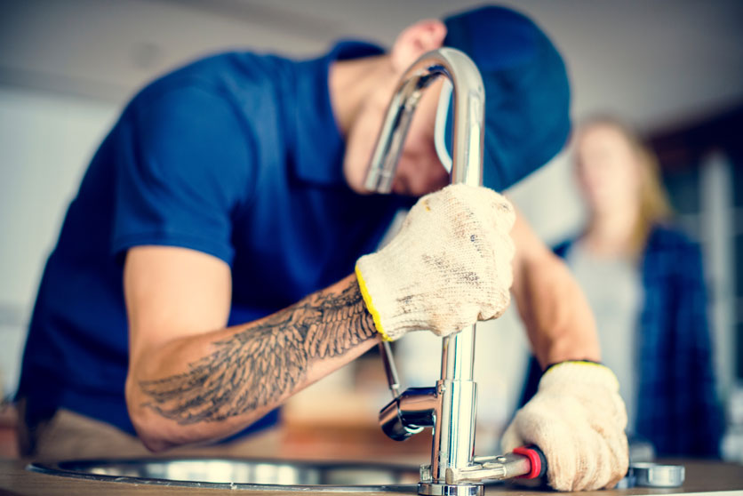 Plumber fixing kitchen sink